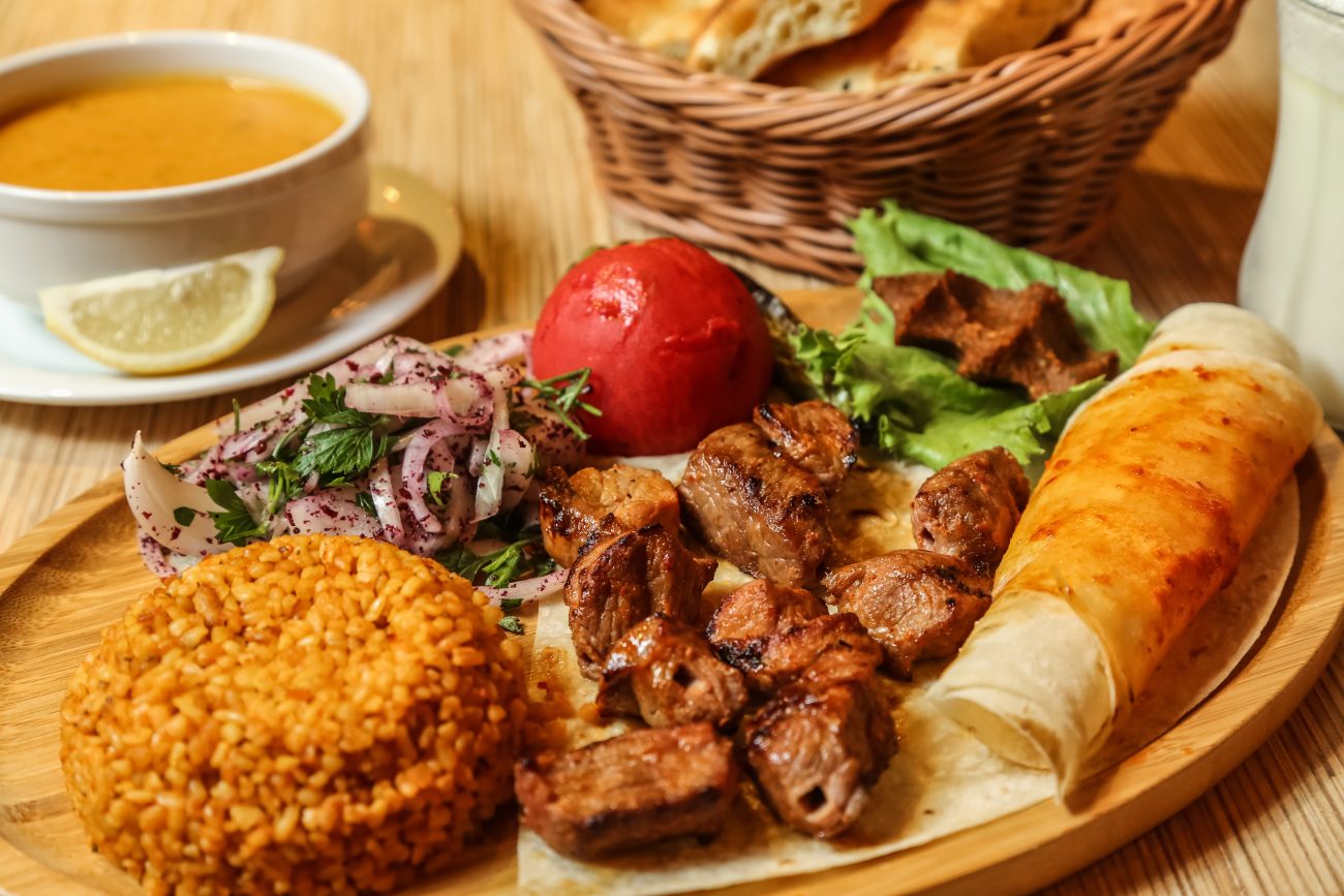 Beef kebab wrapped in lavash with onions, greens, and bulgur